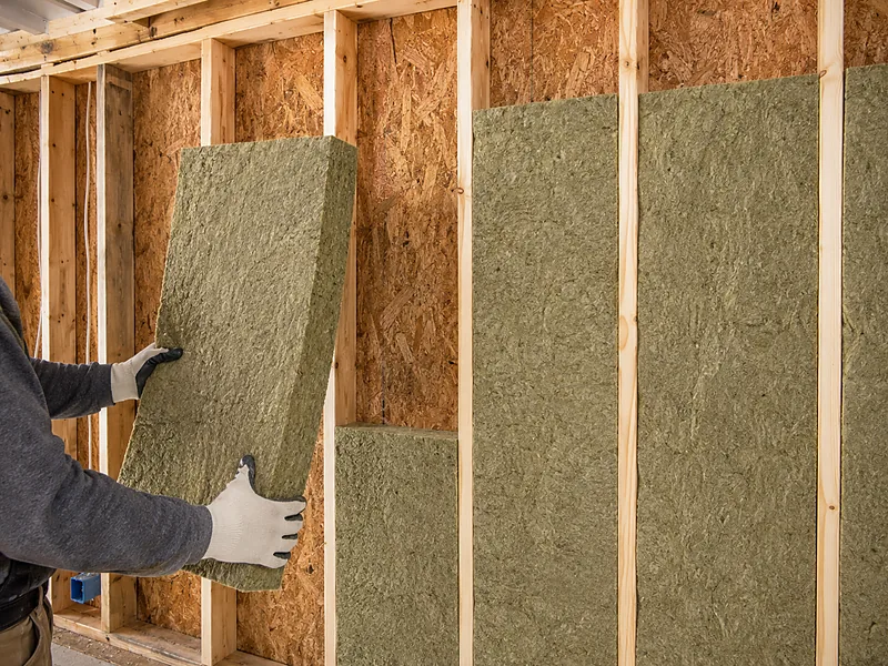 Mineral wool batts friction-fit into a framed wall