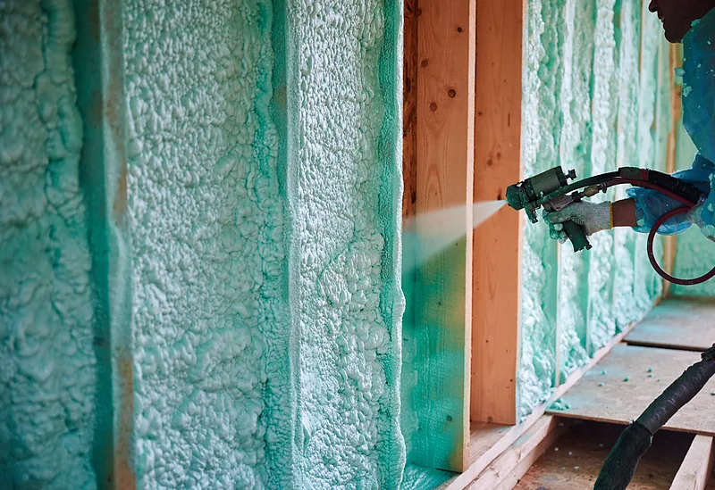 Sealing new-construction stud bays with spray foam